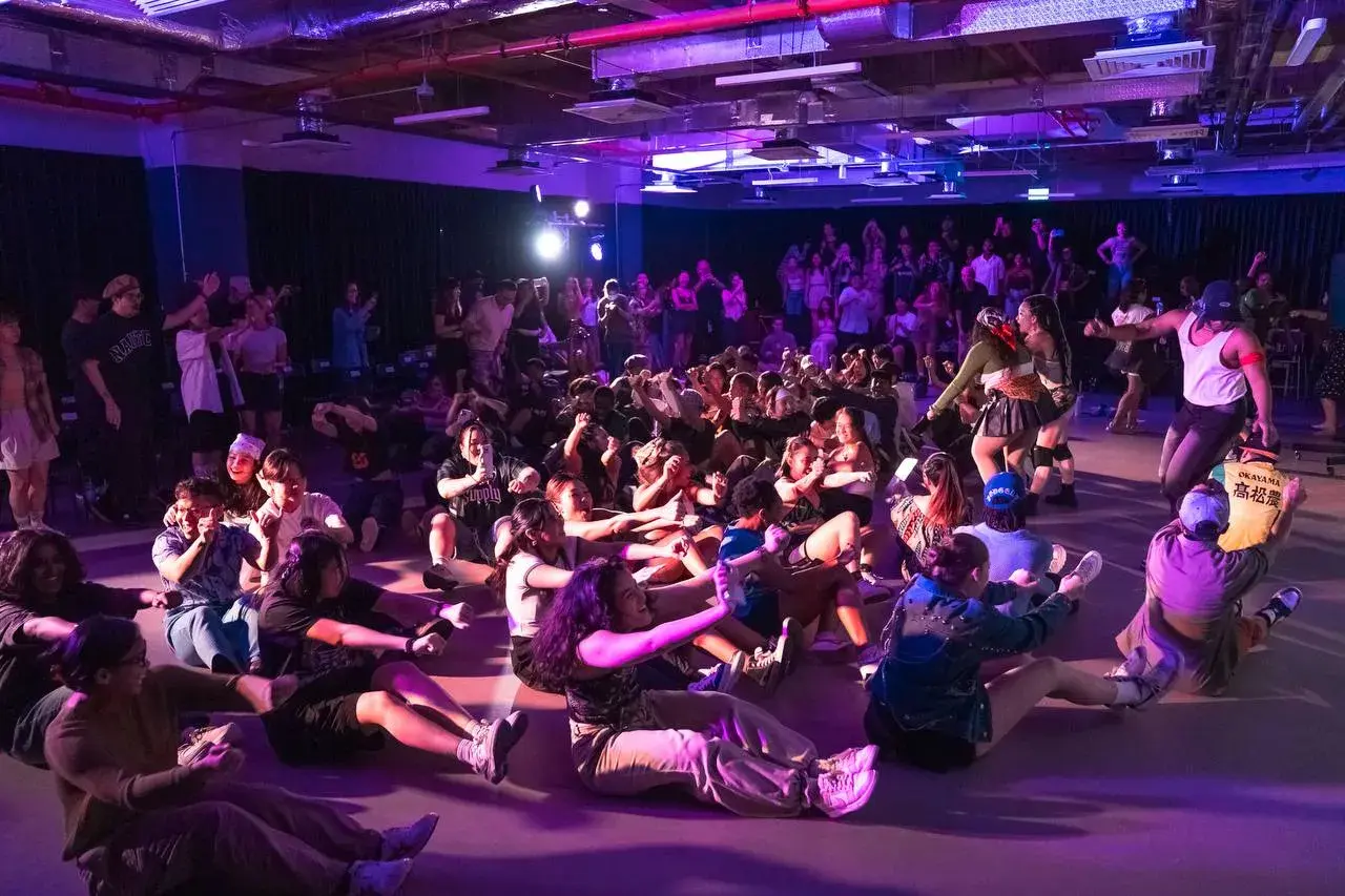 Participants watching a class under stage lighting