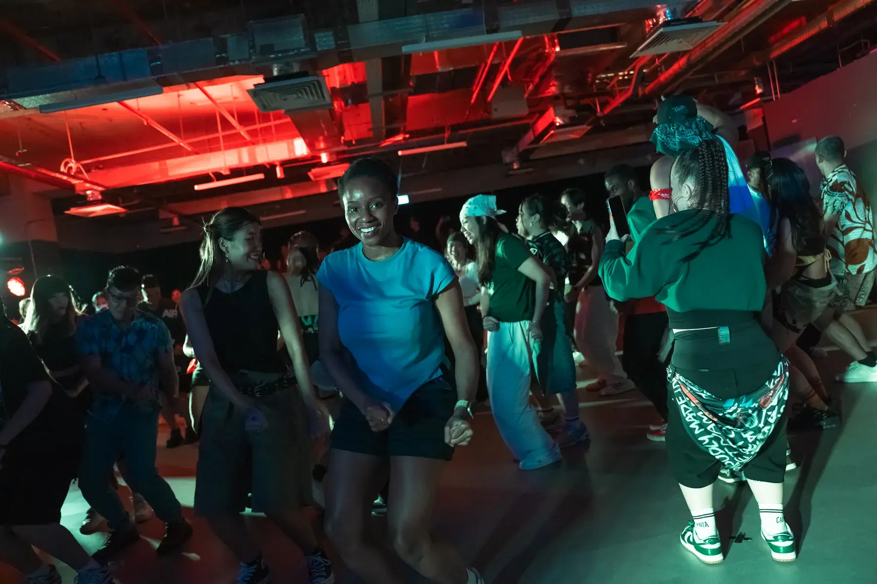 Dancers filling the floor together at ACE 2025 under warm stage lighting.